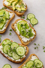 Vegetarian green sandwiches with avocado and cucumber with microgreens on a light background