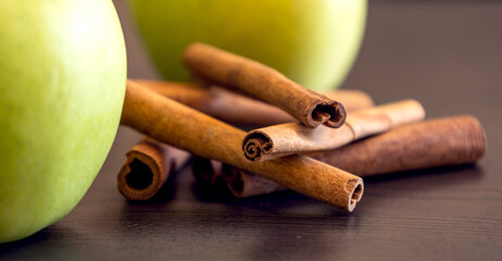 fresh green apples with cinnamon sticks close up