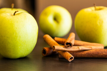 fresh green apples with cinnamon sticks close up