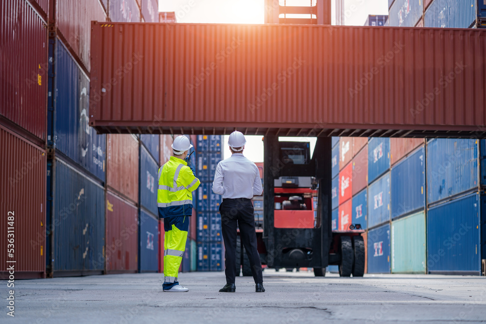 Poster Manager and Technicians planning the transportation of goods for import Or export in the container yard,Checking on shipping containers.