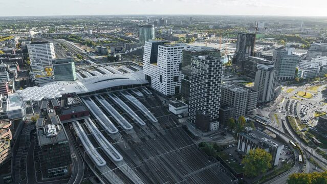 4k aerial time lapse of illuminated Utrecht central train station during rush hour with trains arriving and departing