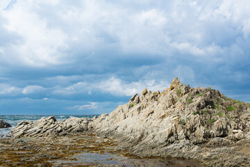 ocean shore with rocks of columnar basalt, Cape Stolbchaty on Kunashir Island