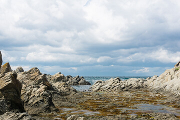 ocean shore with rocks of columnar basalt, Cape Stolbchaty on Kunashir Island