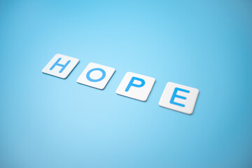 Word HOPE on blue background,business concept. Beautiful blue background. Close up.