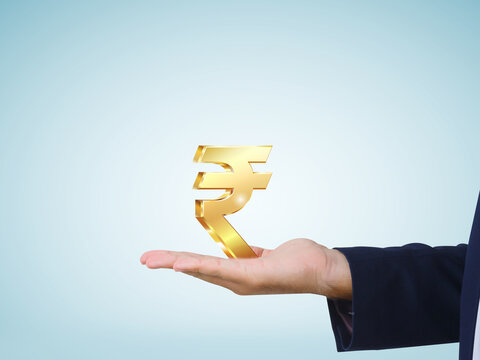 Businessman showing a golden Indian rupee symbol on sky blue background, business, finance and investment image