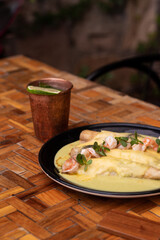 Mexican enchiladas with shrimps and cheese. With a lemonade cup.