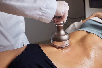 procedure removing cellulite on female abdomen, cavitation belly massage. Ultrasonic massage for...