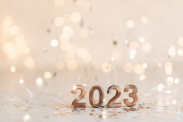 Holiday background Happy New Year 2023. Numbers of year 2023 made by gold candles on bokeh festive sparkling background. celebrating New Year holiday, close-up. Space for text - Powered by Adobe