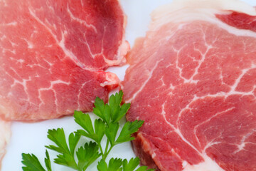 Raw Pork Slice in White Round Plate decorated with parsley. Fresh raw pork.