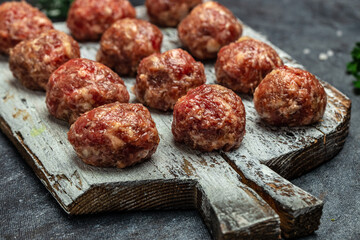 Raw meatballs, minced pork meat on white plate dark background. Culinary, cooking concept. Food recipe background. Close up