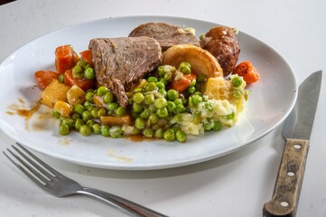 Photo of a roast bee dinner with vegetables on a plate
