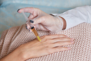 Doctor doing stem cell therapy on a patient's elbow after the injury. Treating knee pain with...