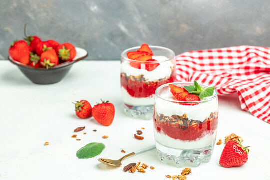 Parfait with yogurt, granola, jam, fresh berries and mint leaves in glass jar. gluten free diet, Healthy breakfast. banner, menu, recipe place for text