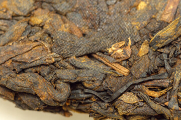 Pressed Chinese fermented Pu erh tea. Macro close up. Aromatic black puer tea. Selective focus
