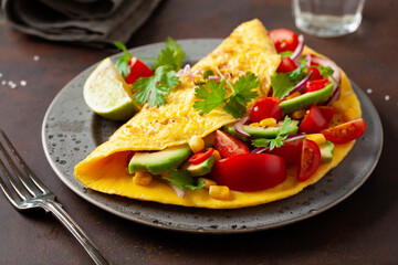 omelette with tomato, avocado onion chili and sweet corn. healthy keto diet low carb breakfast