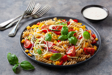 healthy pasta salad with zucchini sweet corn tomato and basil, vegetarian lunch
