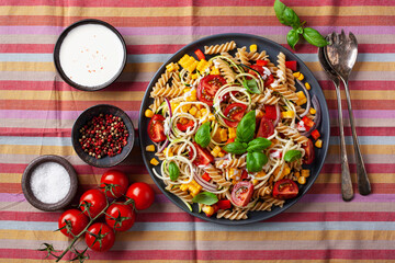 healthy pasta salad with zucchini sweet corn tomato and basil, vegetarian lunch