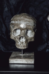 Human skull made of concrete on a stand. Interior decor.