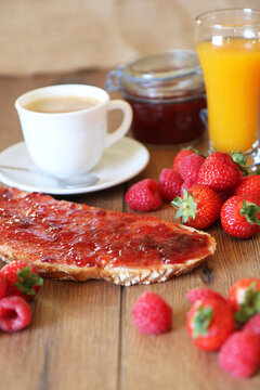 Desayuno, tosatada de mermelada de fresas, zumo de naranja y caf&eacute;.