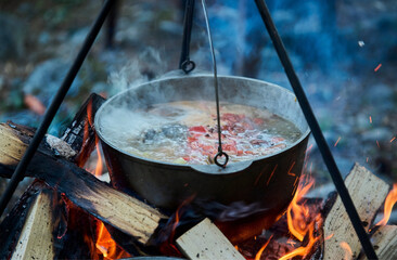 Cooking fish soup in the stowed bowler over a campfire.