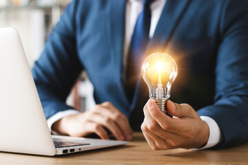 Innovation through ideas and inspiration ideas. Human hand holding light bulb to illuminate, idea...