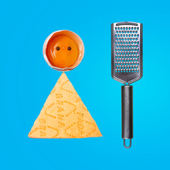 Fototapeta Egg, Parmesan, and cheese grater. Photo on a blue summer background. A modern concept. Place for text. Perfect dinner and breakfast. Diet. obraz