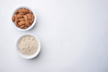 Fototapeta na wymiar almond powder and almond in a jar on white background 