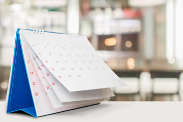 desk calendar on table with blurred bokeh background appointment and business meeting concept