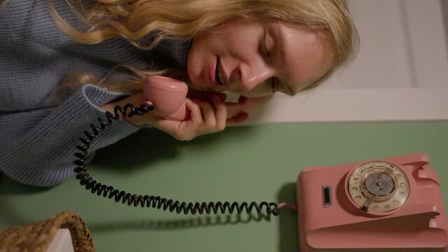 Blond woman, calls on a retro phone, rose telephone, vertical video. slow motion