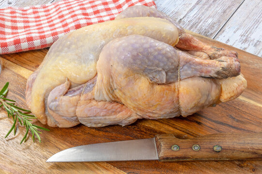 pintade enti&egrave;re en gros plan sur une planche &agrave; d&eacute;couper