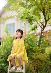 cute little Asian girl holding Sandpaper Vine flower