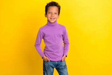 Photo portrait of cute small pupil boy hold hands pockets enjoy shopping dressed stylish purple garment isolated on yellow color background