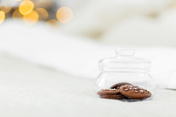 Star-shaped chocolate chip cookies in a glass jar against the backdrop of Christmas lights