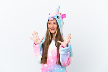 Little caucasian girl wearing unicorn pajama isolated on white background with surprise facial...