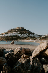 The serene view of Lindos Beach and The Acropolis in Rhodes. Rocks, sand, beach, waves, sea, blue...