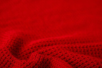 Knitted surface of woolen things as a background. Close-up of soft fabric red color knitted...