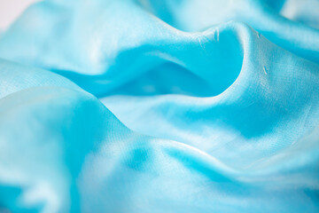 Satin fabric close up background and texture with place for text. Light blue chiffon or silk...