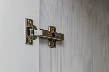 Furniture door hinge on a white door