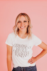 Obraz premium Woman stands confidently against pink backdrop looking at camera