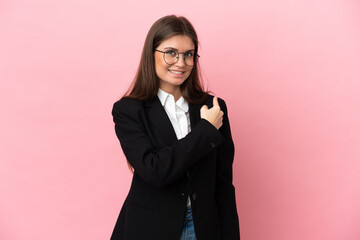 Young Business caucasian woman isolated on pink background pointing back