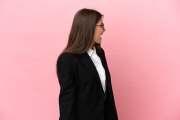 Young Business caucasian woman isolated on pink background laughing in lateral position