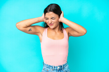 Fototapeta na wymiar Young caucasian woman isolated on blue background frustrated and covering ears