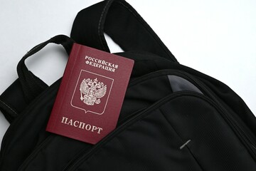 Russian passport sticking out of a backpack. Leisure or business trip out of Russia or young men fleeing mobilization 