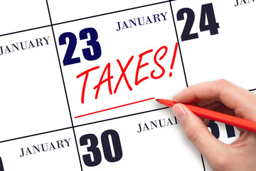 Hand drawing red line and writing the text Taxes on calendar date January 23. Remind date of tax payment - obrazy, fototapety, plakaty
