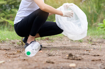 woman is collecting recycling junk on ground , ecological sustainable concept .