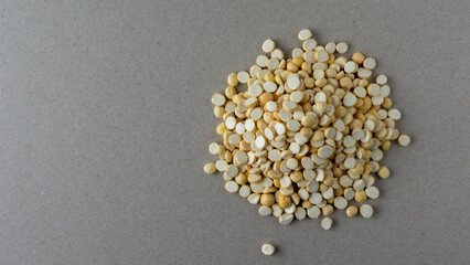 pile of roasted or fried bengal gram on a gray textured background, also known as chenna dal or...