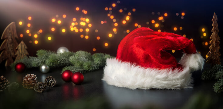 Christmas decoration arrangement with Santa's hat, ornaments and lights on dark background