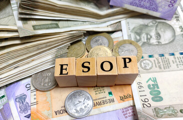 ESOP or employee stock ownership plan by letters on wooden beads or block with Indian rupee notes and coins.