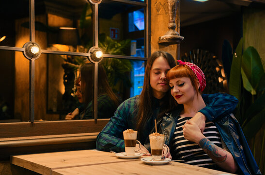 Lovely pin-up couple sitting in a cafe with their eyes closed