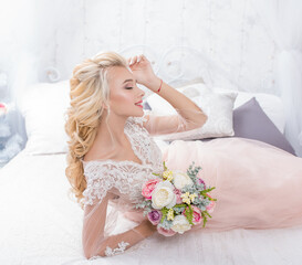 Obraz na płótnie Canvas Beautiful bride in wedding dress posing with bouquet in hands